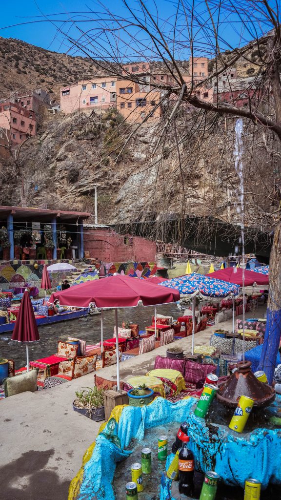 restaurant coloré devant la rivière avec village en fond sur colline